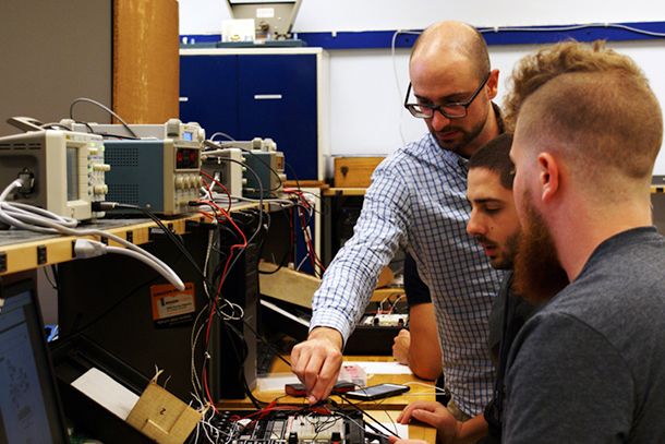 Joseph Cuiffi works with students during an electrical engineering lab